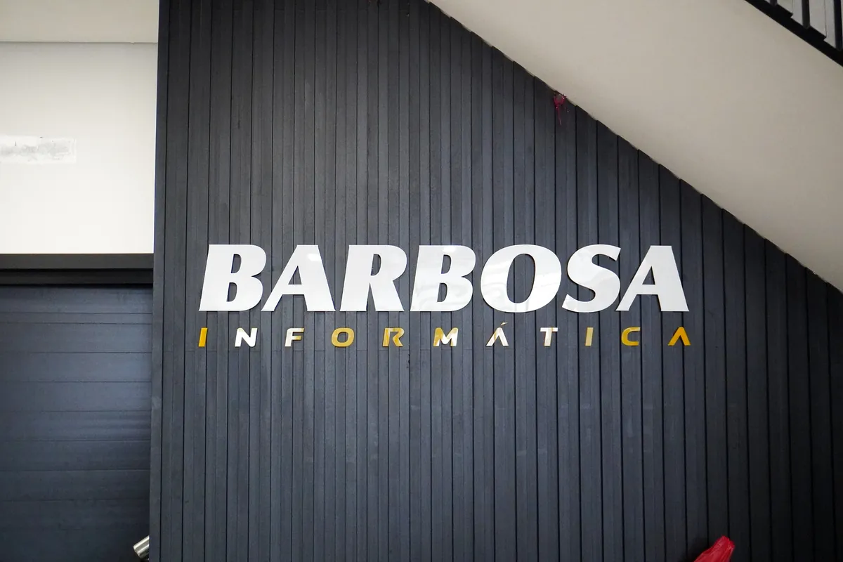 Letreiro Barbosa Informática na parede ripada da loja